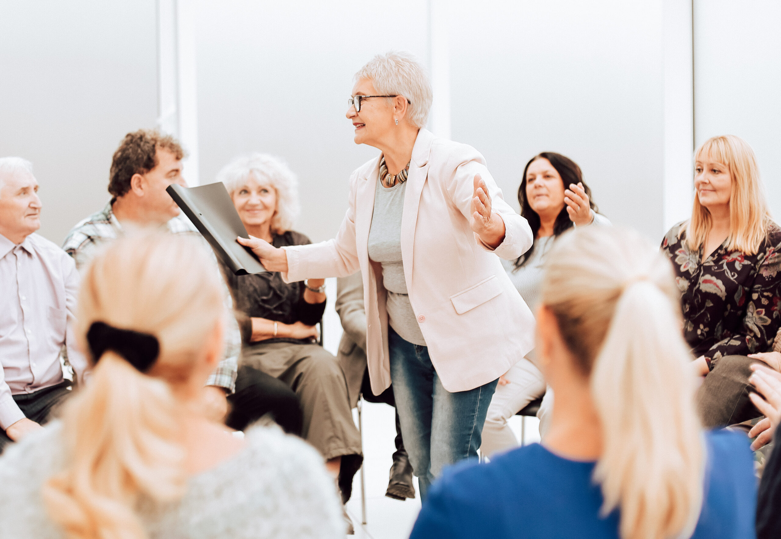 Elderly woman giving a speech to a group of elderly people