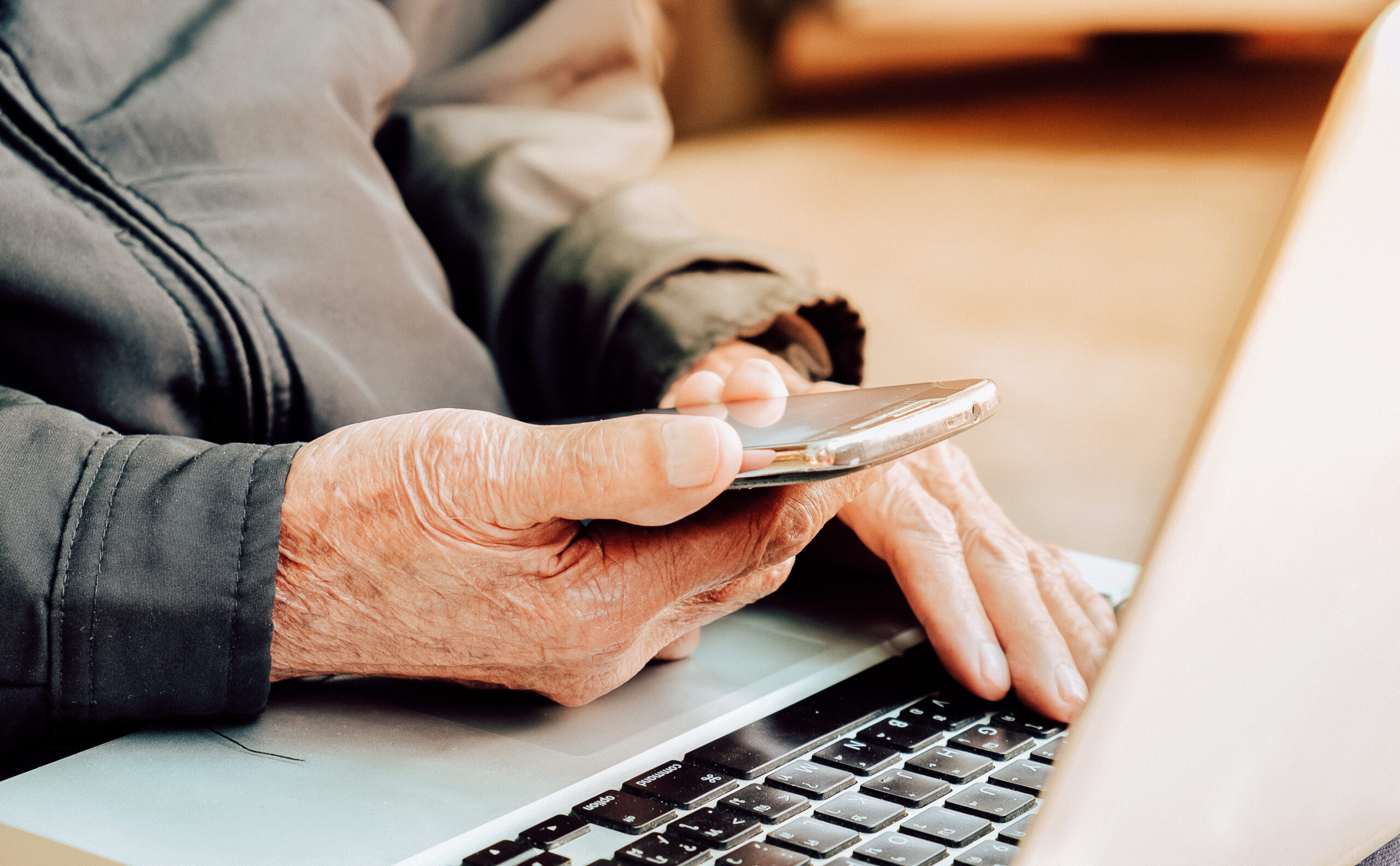 Close up of a business old man using mobile smart phone and laptop Close up of a business old man using mobile smart phone and laptop
