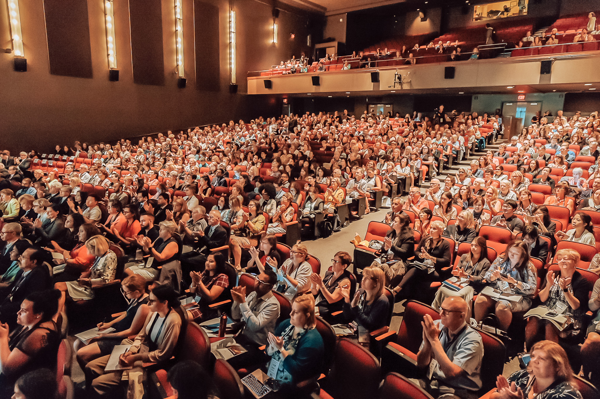 group of people gathering in a theater group of people gathering in a theater