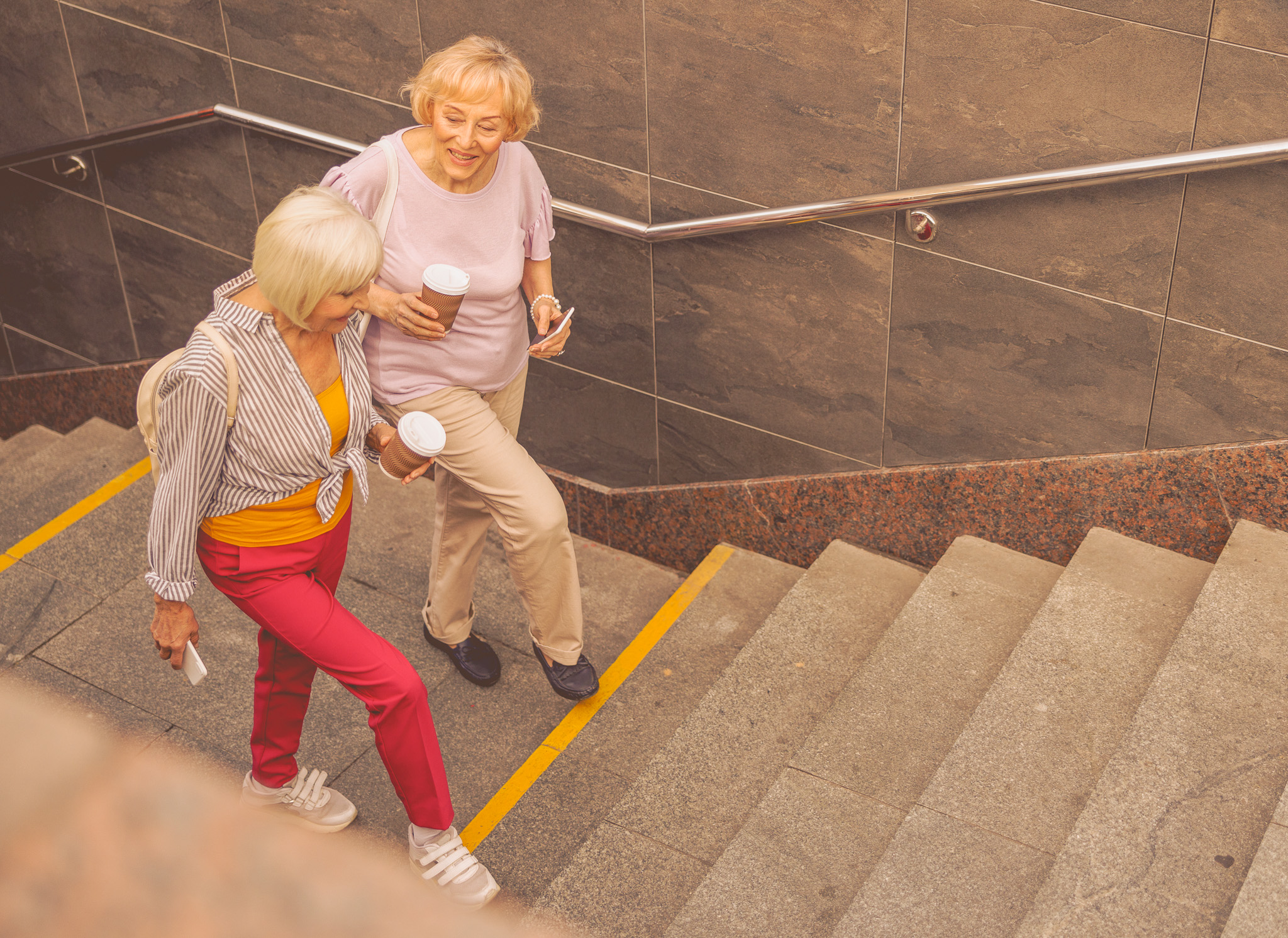 Two,Women,Talking,And,Going,Up,The,Stairs,During,Their Two women talking and going up the stairs during their stroll